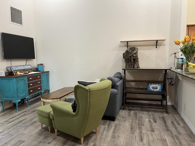 living area with baseboards, wood finished floors, and visible vents