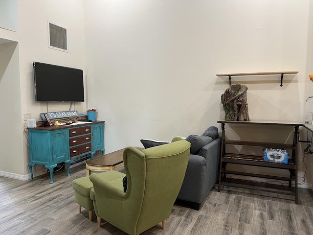 living area with baseboards, wood finished floors, and visible vents