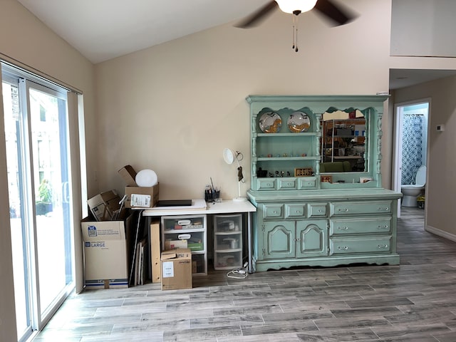 bar with a ceiling fan and wood finished floors