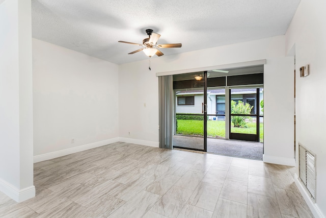 unfurnished room featuring ceiling fan and a textured ceiling