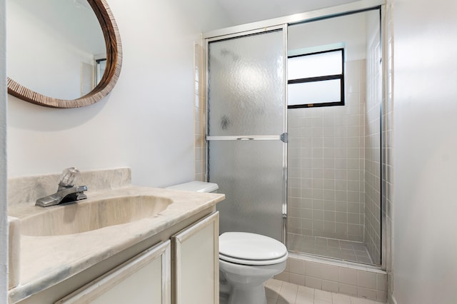 bathroom featuring a shower with door, tile patterned floors, vanity, and toilet