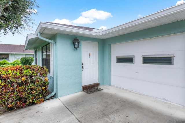 4360 Eucalyptus Tree Ct Unit A, Boynton Beach, FL 33436 - view of exterior entry featuring an attached garage and stucco siding