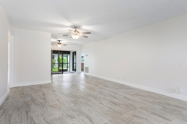 unfurnished room featuring ceiling fan and a textured ceiling