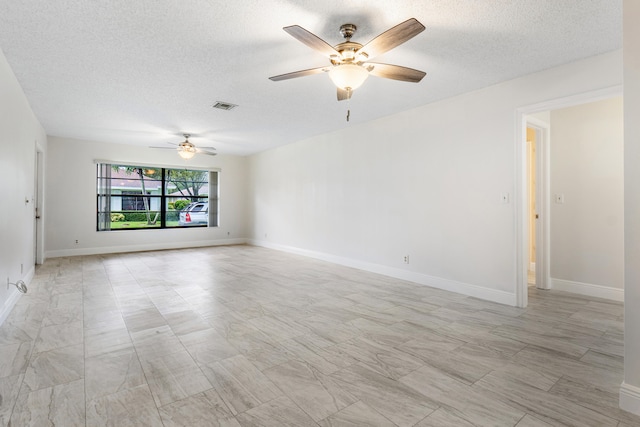 empty room featuring ceiling fan and a textured ceiling