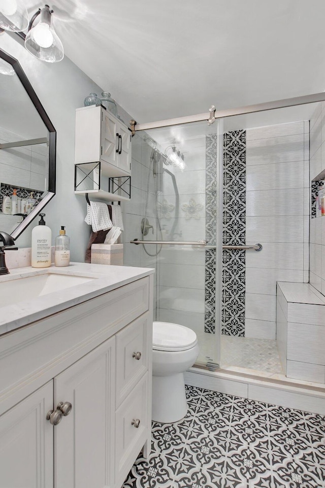 bathroom featuring toilet, vanity, and walk in shower