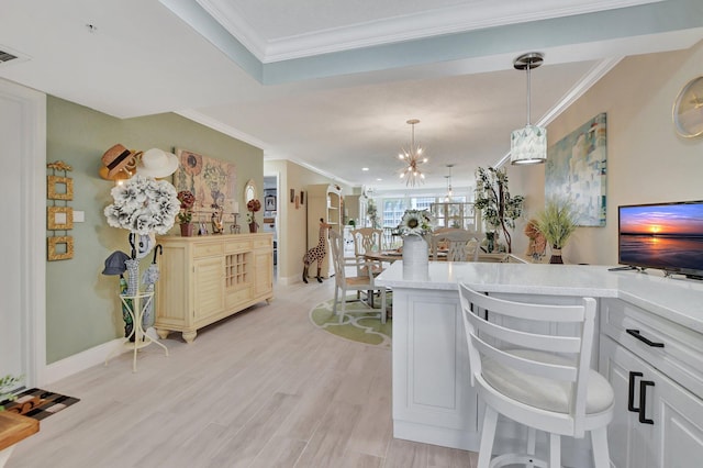 kitchen featuring light hardwood / wood-style floors, crown molding, decorative light fixtures, white cabinets, and a chandelier