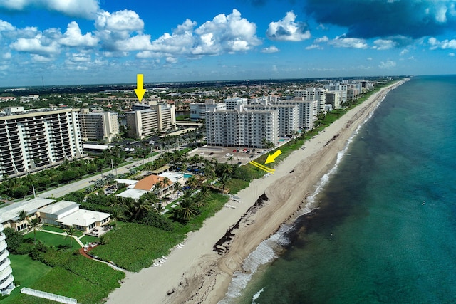 birds eye view of property featuring a water view and a beach view