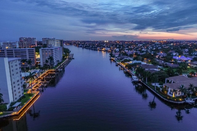 aerial view at dusk featuring a water view