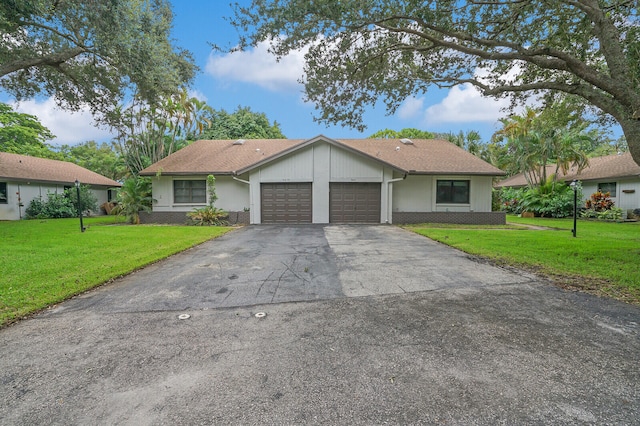 single story home featuring a front lawn and a garage