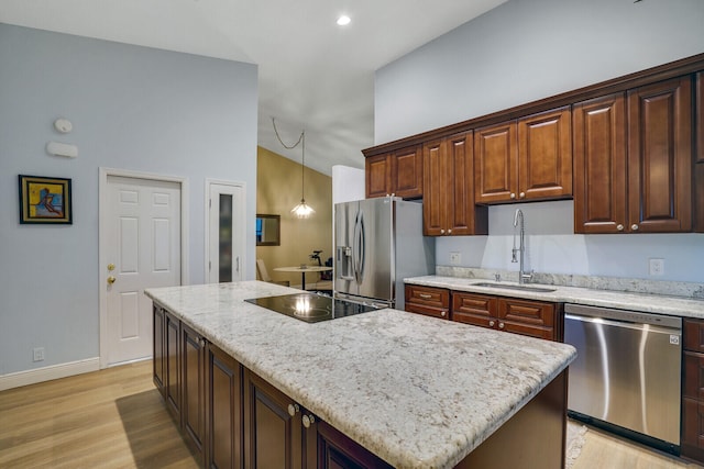 kitchen featuring stainless steel appliances, sink, a center island, pendant lighting, and high vaulted ceiling