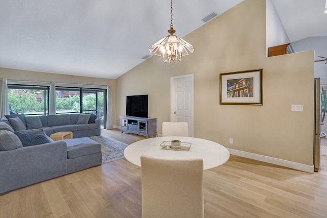 living room featuring a notable chandelier, high vaulted ceiling, and light wood-type flooring