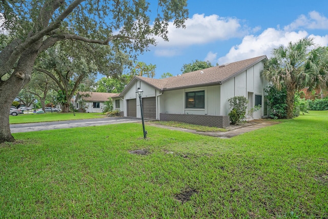 single story home featuring a garage and a front lawn