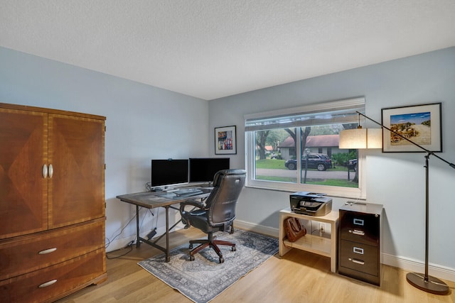 office area with a textured ceiling and light wood-type flooring