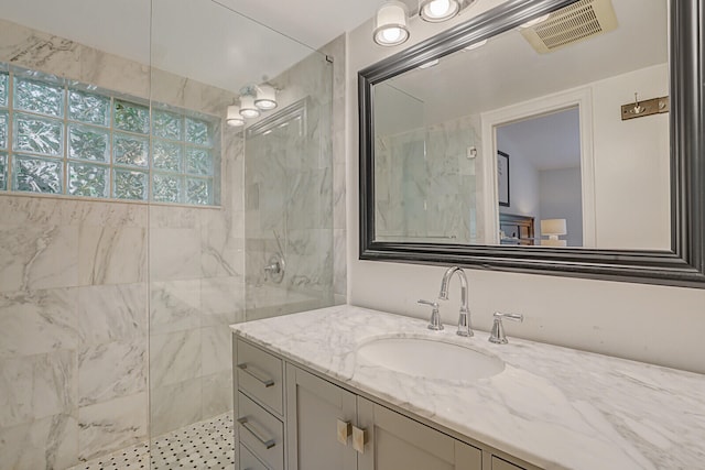 bathroom with vanity and a tile shower