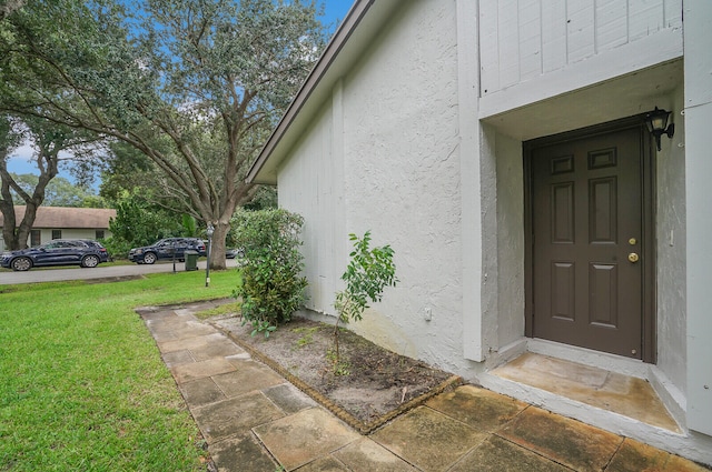 doorway to property with a lawn