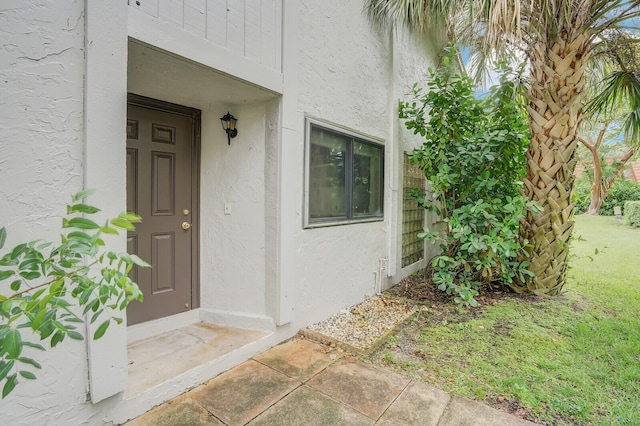 doorway to property with a yard