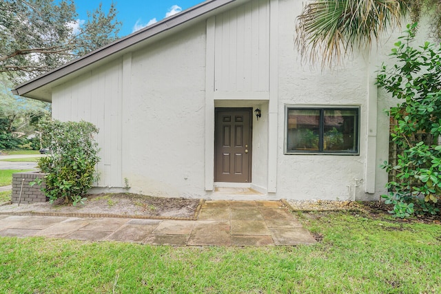 entrance to property featuring a lawn