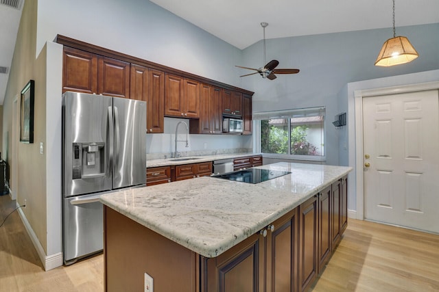 kitchen featuring a kitchen island, light hardwood / wood-style flooring, sink, pendant lighting, and appliances with stainless steel finishes