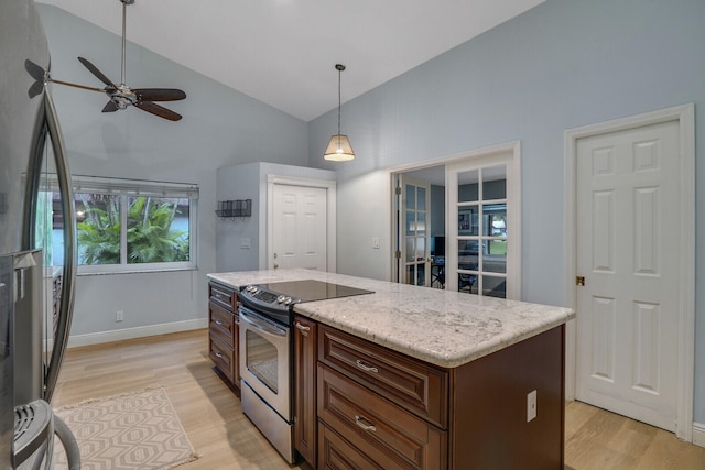 kitchen featuring appliances with stainless steel finishes, decorative light fixtures, light hardwood / wood-style floors, and a kitchen island