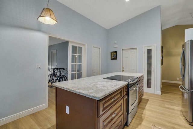 kitchen featuring light hardwood / wood-style floors, decorative light fixtures, a kitchen island, and stainless steel appliances