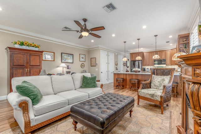 living room with ceiling fan, crown molding, and light hardwood / wood-style floors