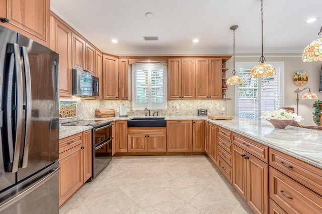 kitchen with pendant lighting, crown molding, sink, light stone counters, and appliances with stainless steel finishes