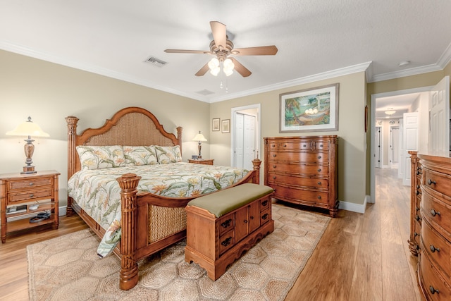 bedroom featuring a closet, light hardwood / wood-style floors, ornamental molding, and ceiling fan