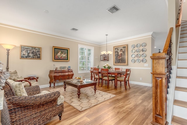 dining area with an inviting chandelier, light hardwood / wood-style floors, and ornamental molding