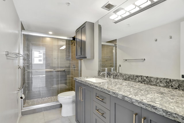 bathroom featuring tile patterned floors, vanity, walk in shower, and toilet