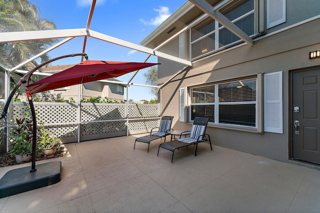 view of patio featuring glass enclosure