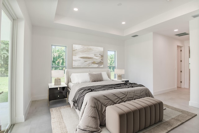 bedroom featuring a tray ceiling and access to exterior