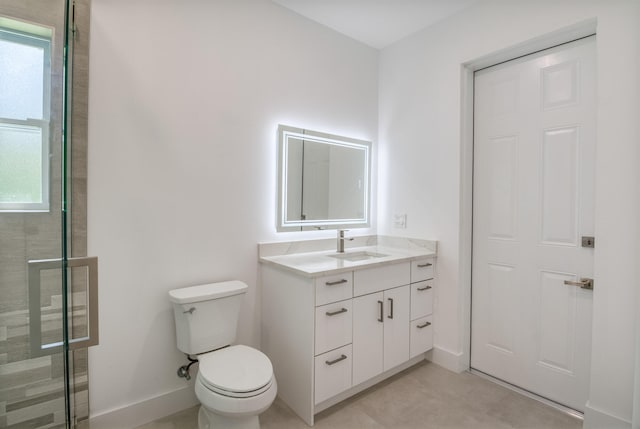 bathroom featuring vanity, a shower with shower door, toilet, and a healthy amount of sunlight