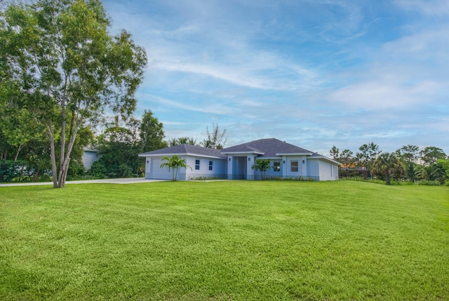 ranch-style house featuring a garage and a front lawn