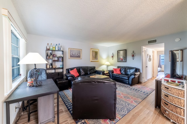 living room with light hardwood / wood-style flooring and a textured ceiling