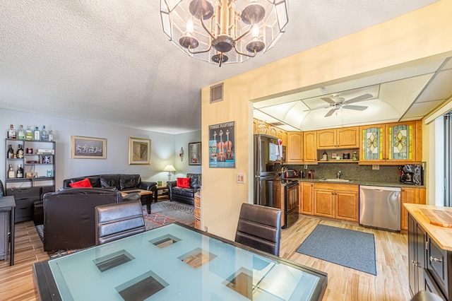 kitchen featuring light hardwood / wood-style flooring, sink, decorative backsplash, black electric range, and stainless steel dishwasher