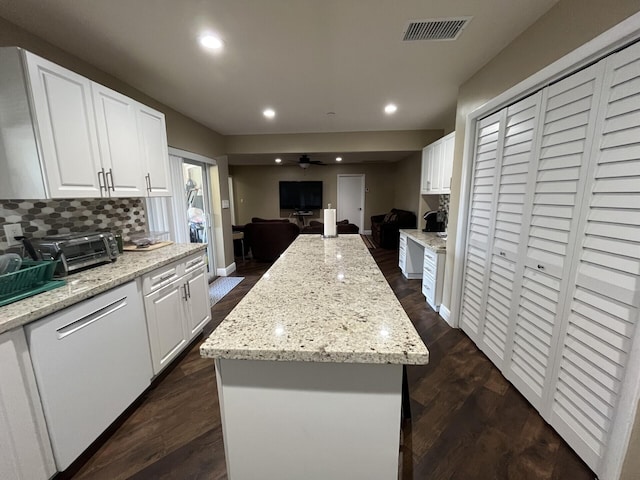 kitchen featuring white cabinets, dark wood-type flooring, tasteful backsplash, and a center island