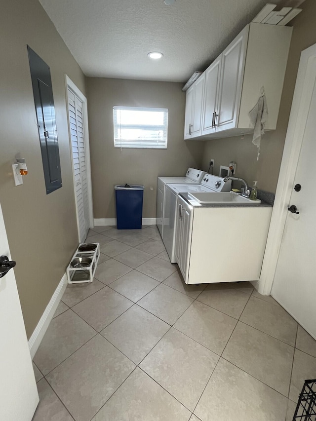 laundry area with light tile patterned flooring, electric panel, cabinets, washer and dryer, and a textured ceiling