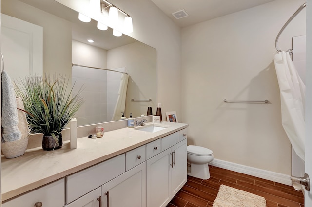 bathroom featuring toilet, hardwood / wood-style floors, curtained shower, and vanity