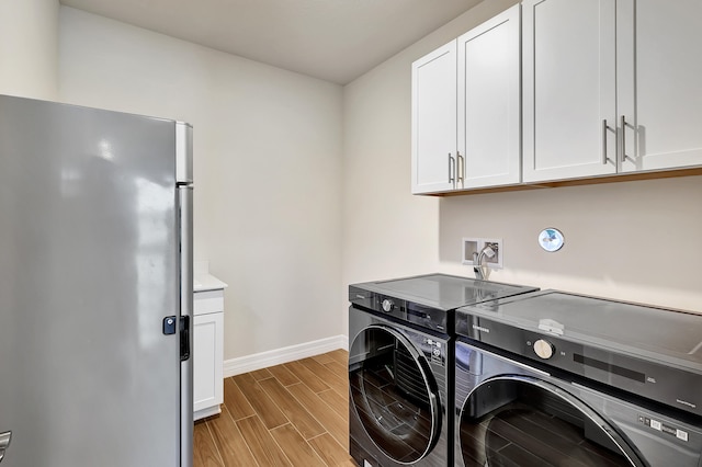 washroom with washing machine and dryer and light wood-type flooring