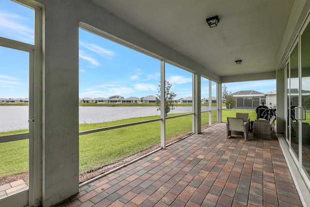 unfurnished sunroom featuring a water view