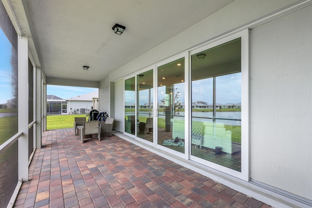 unfurnished sunroom featuring plenty of natural light and a water view