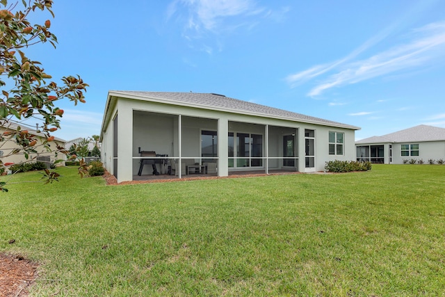 back of house featuring a sunroom and a lawn