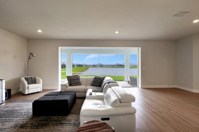 living room with a water view and wood-type flooring