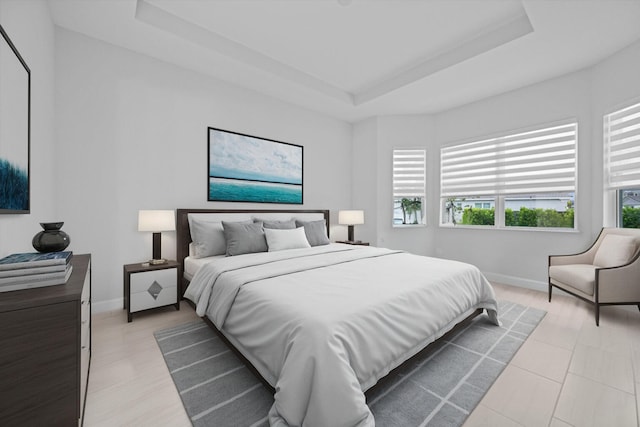 bedroom with a tray ceiling and multiple windows