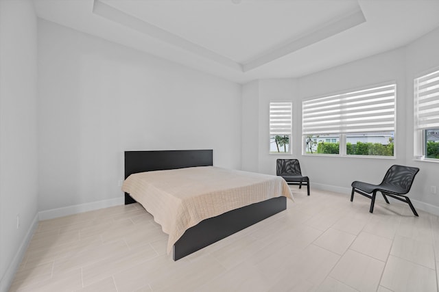 bedroom featuring a raised ceiling and multiple windows