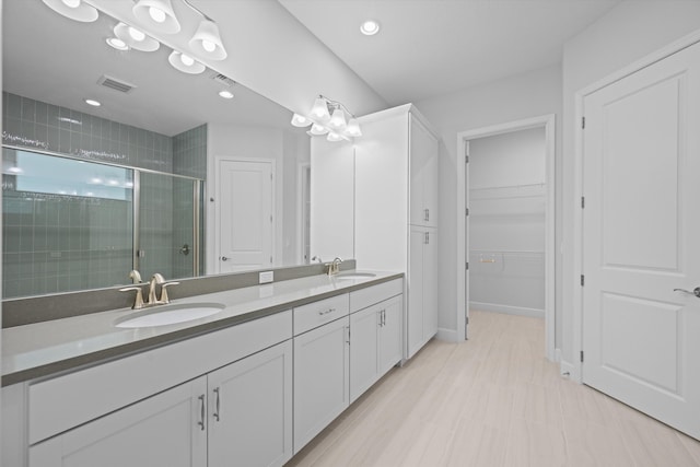 bathroom featuring vanity and a shower with shower door