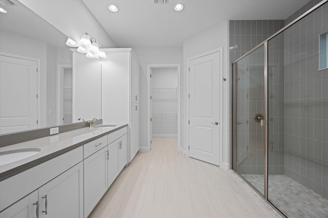 bathroom with a shower with door and vanity