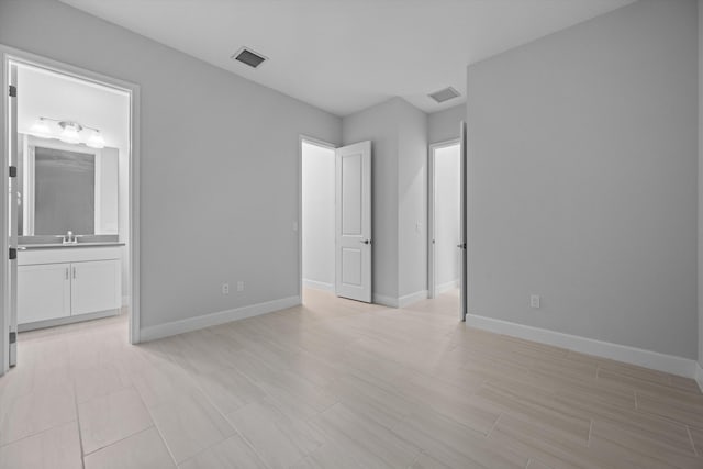 unfurnished bedroom featuring ensuite bathroom and sink