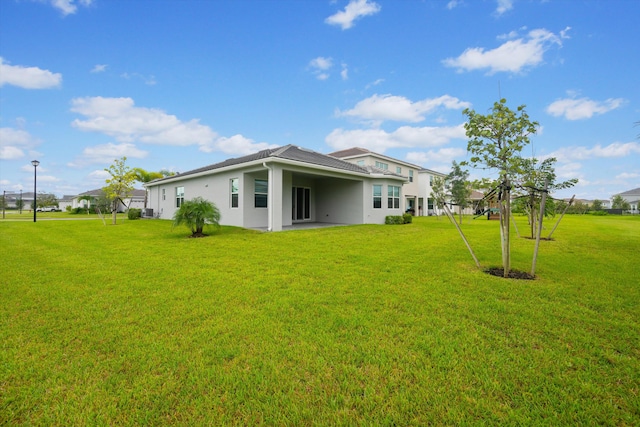 rear view of property featuring a yard