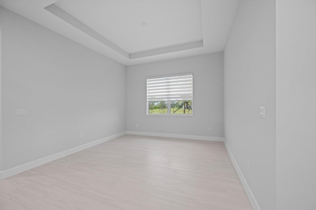 unfurnished room featuring a tray ceiling